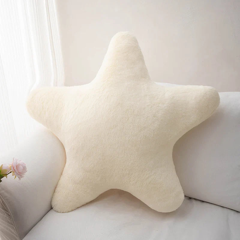 Coussin étoile pastel roseposé sur lit