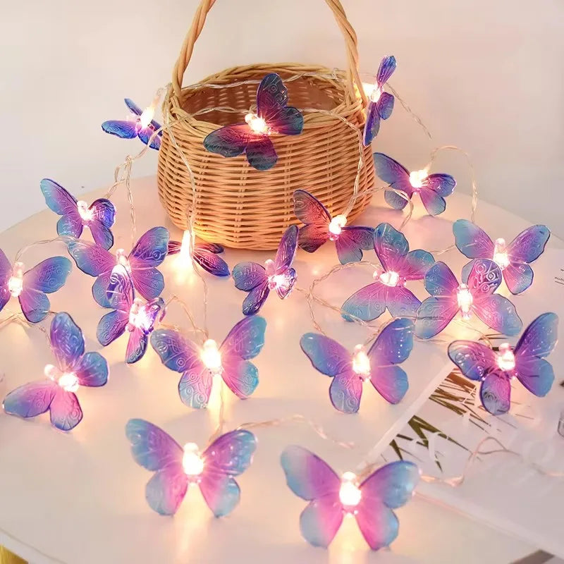 Guirlande LED violette motif papillons, ambiance féerique et colorée pour fêtes et intérieurs contemporains.
