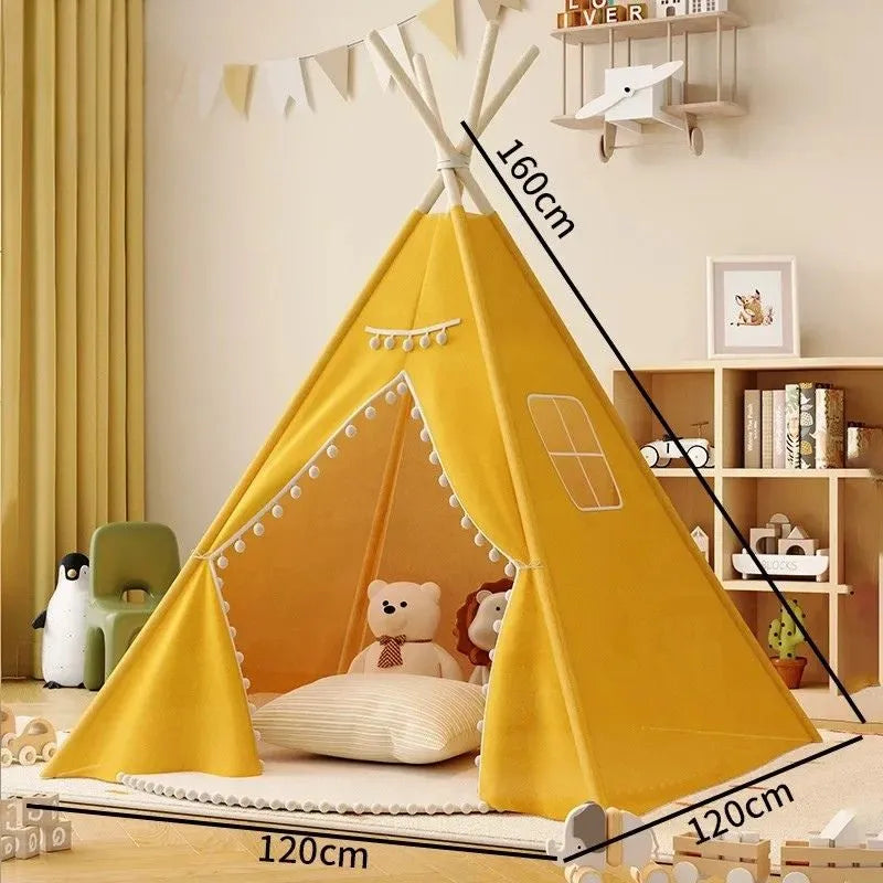 Tipi enfant intérieur jaune avec pompons, un refuge charmant pour les petits explorateurs.