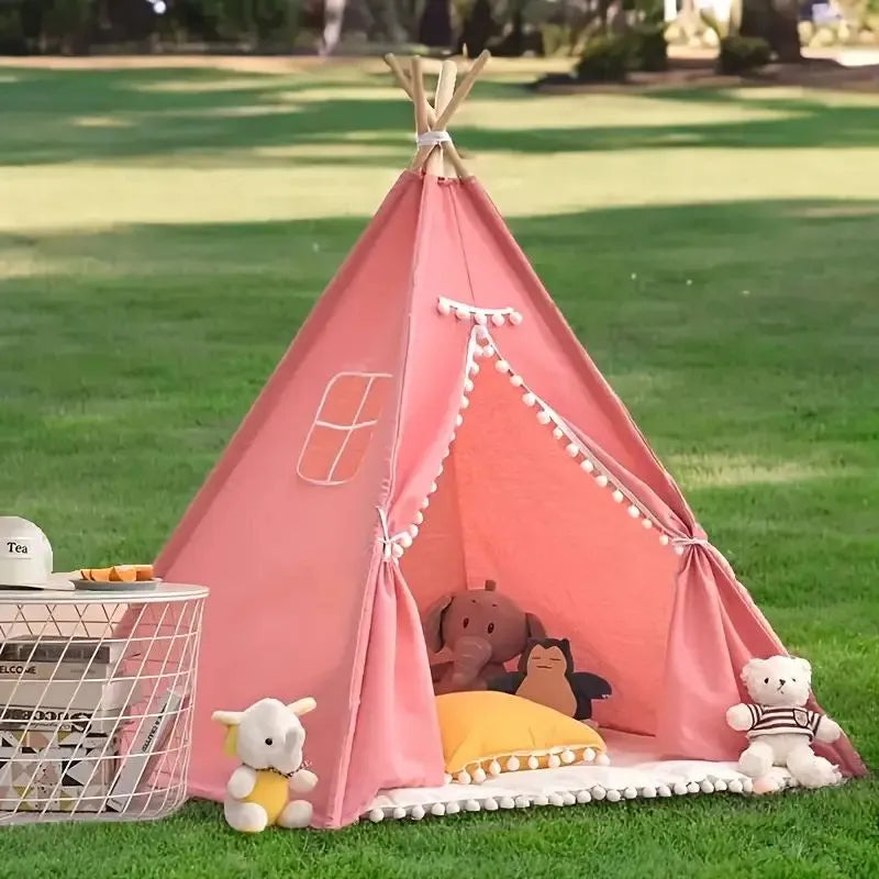 Tipi enfant intérieur rose avec pompons, créant un coin de jeu douillet et chic.