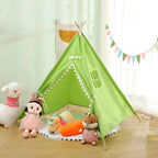 Tipi enfant intérieur vert orné de pompons, idéal pour une chambre à thème nature.